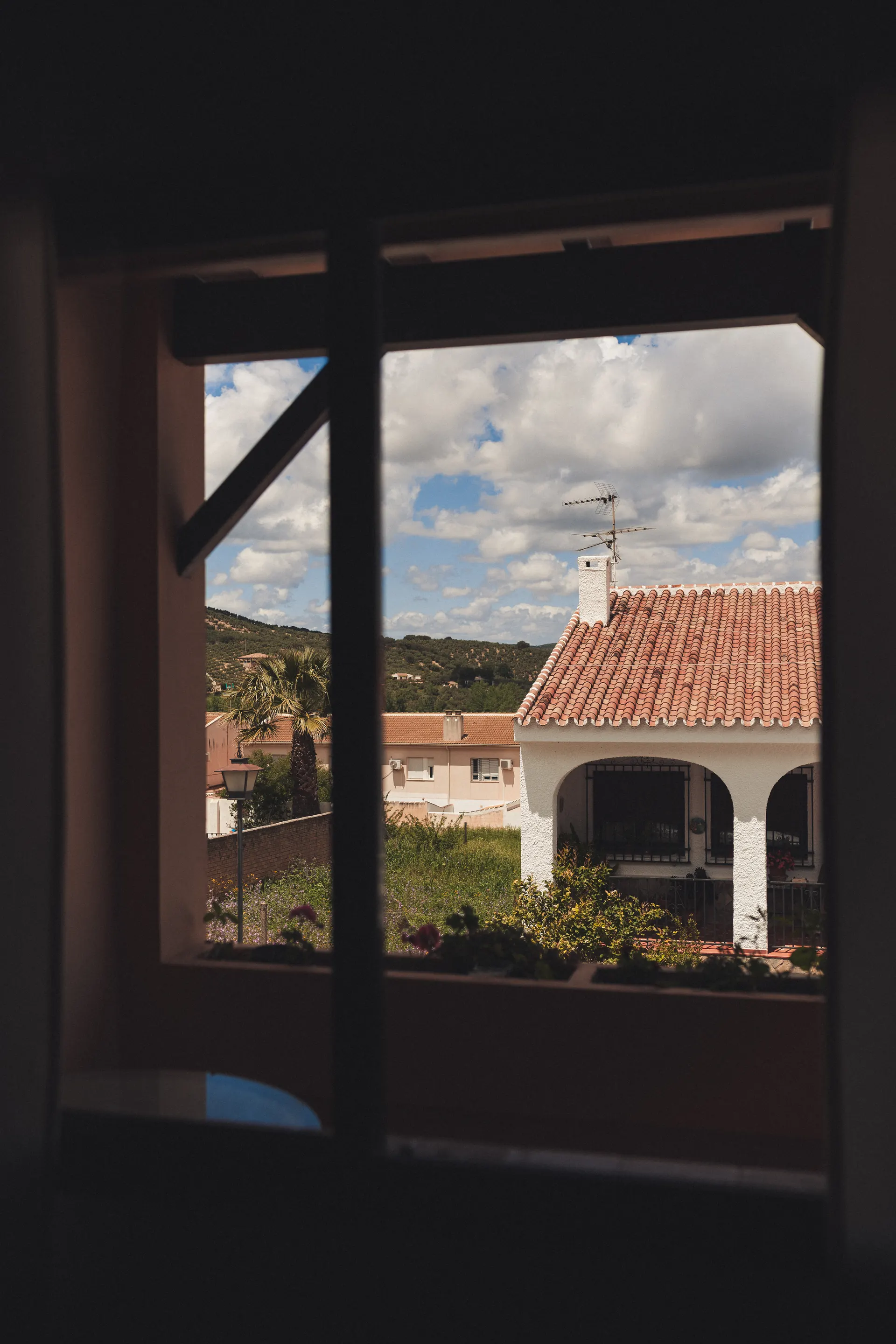 Ventana del dormitorio abierta a las casas del pueblo y la sierra