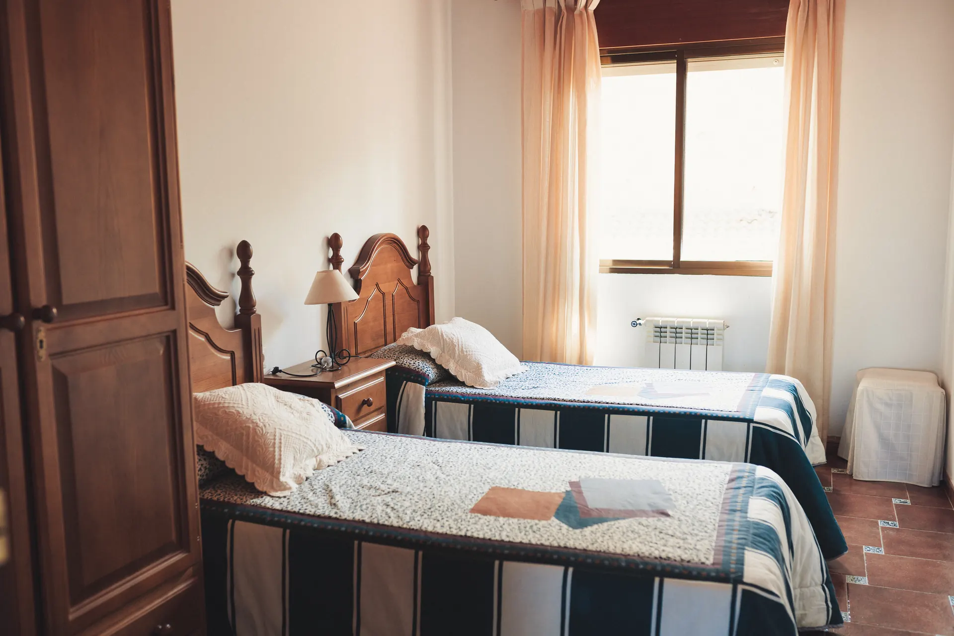 Dormitorio con dos camas individuales y armario de madera