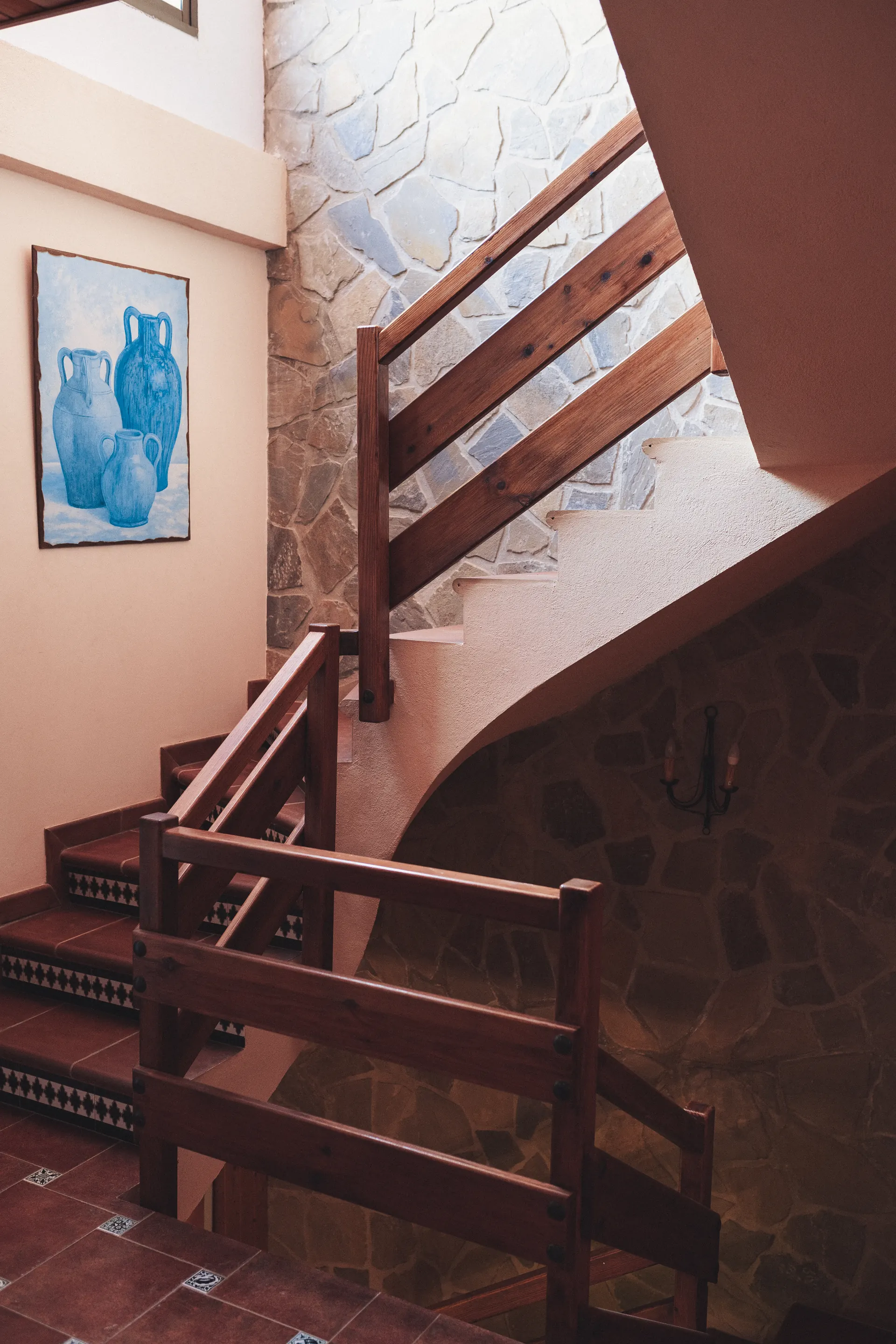 Escalera interior de madera y piedra con peldaños de barro cocido