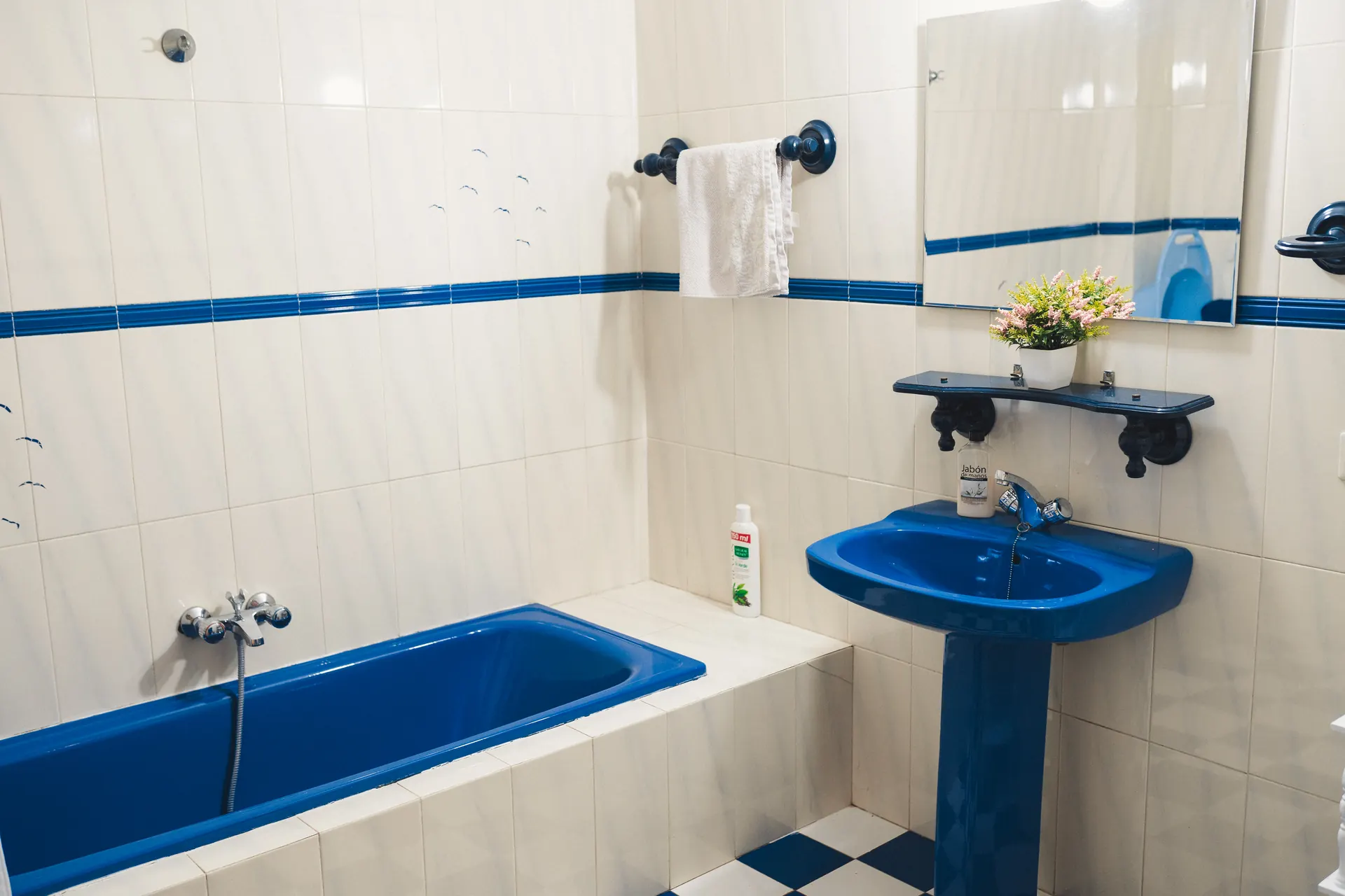 Baño en azul y blanco con bañera y toallero