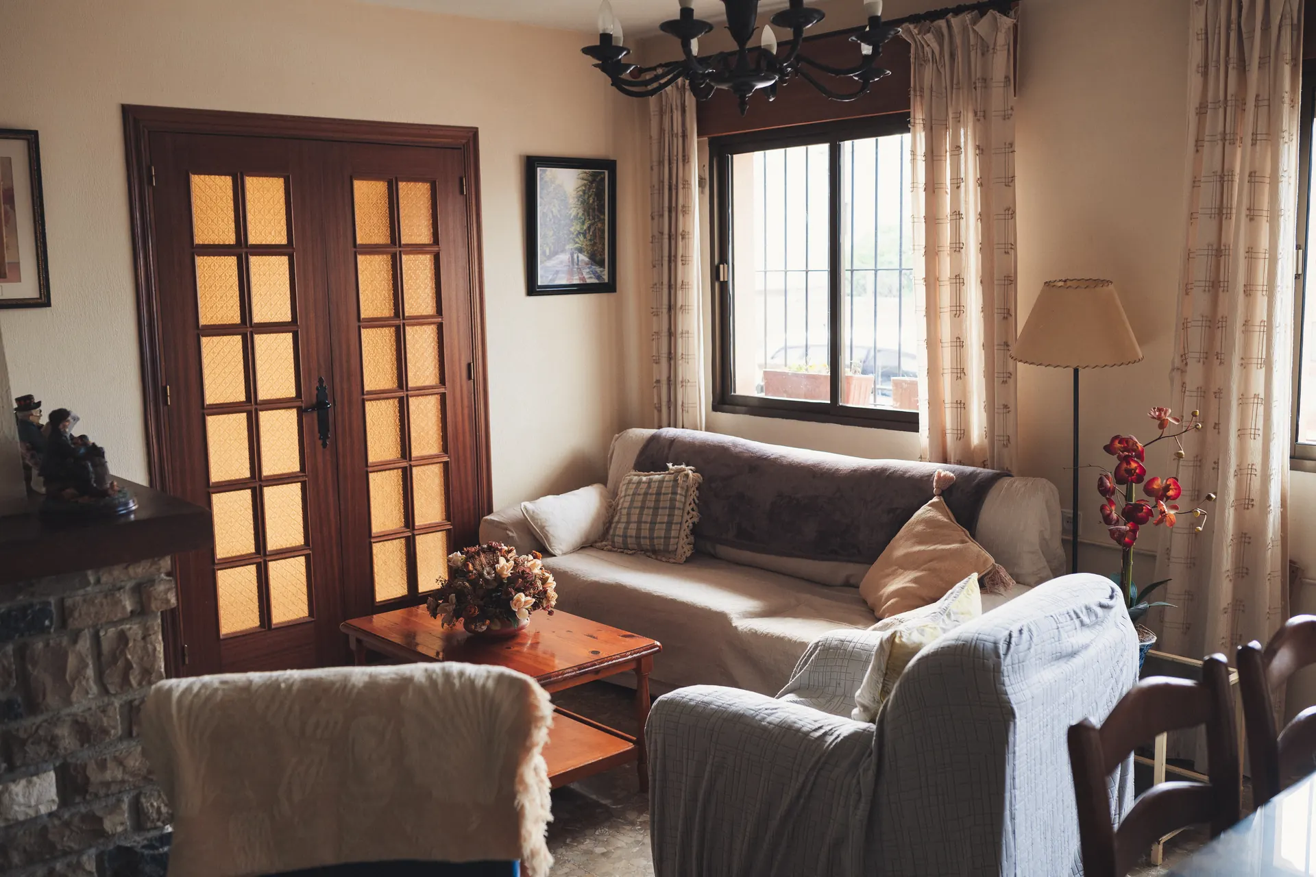 Zona de estar con sofás claros y puertas de madera en el salón