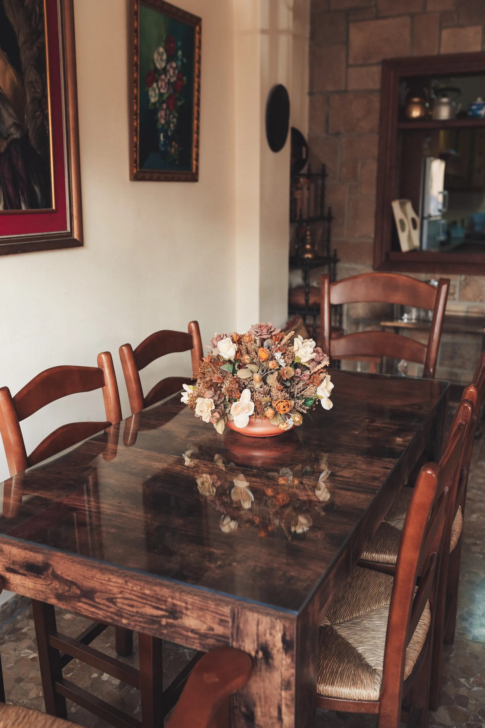 Mesa de comedor de madera con centro de flores secas junto al salón